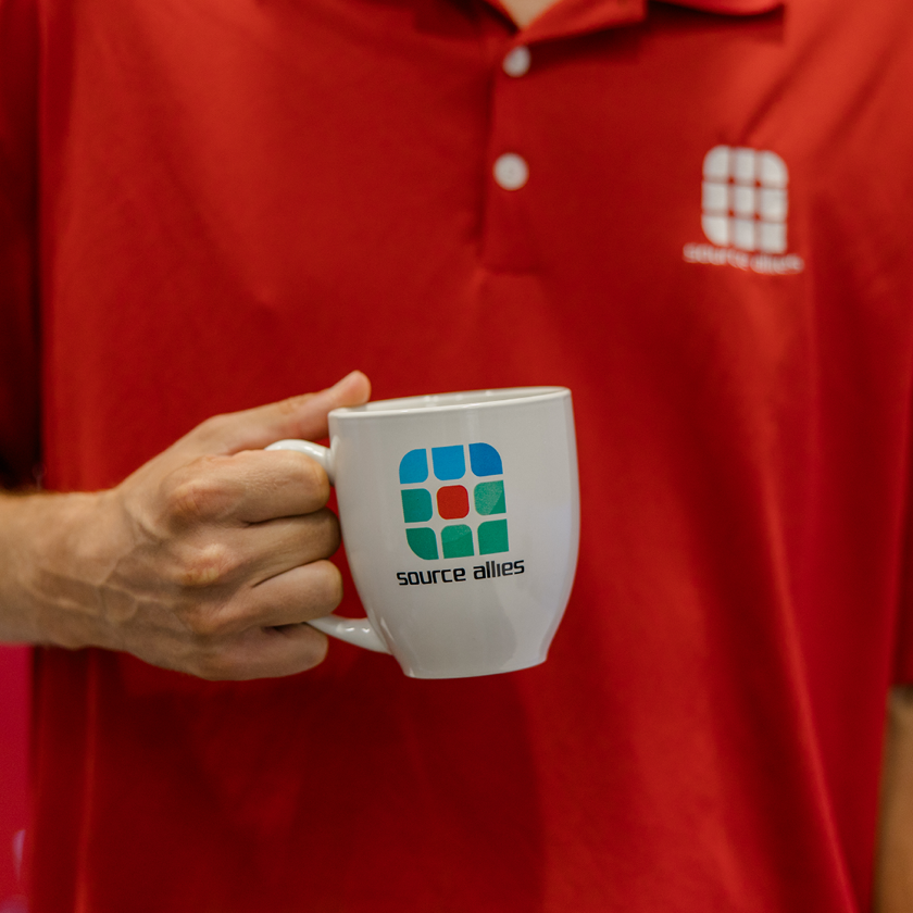 Source Allies teammate holding a branded mug