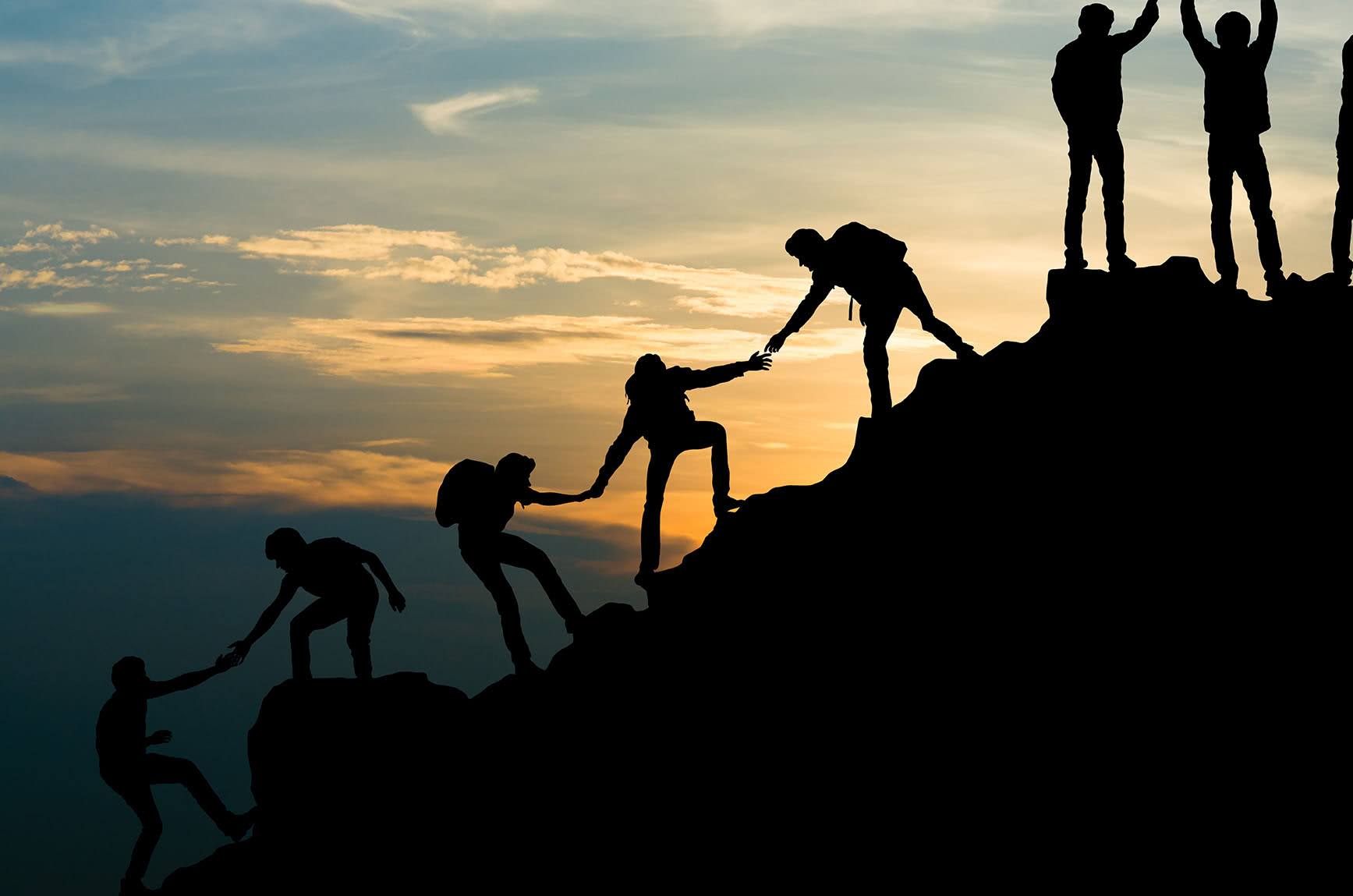 People pulling eachother up a large hill