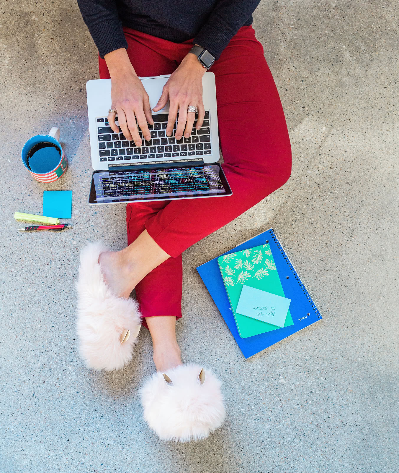 Woman in slippers sits with laptop