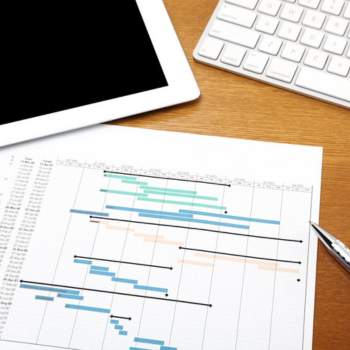 example Gantt chart on a desk with a pen, tablet, and keyboard